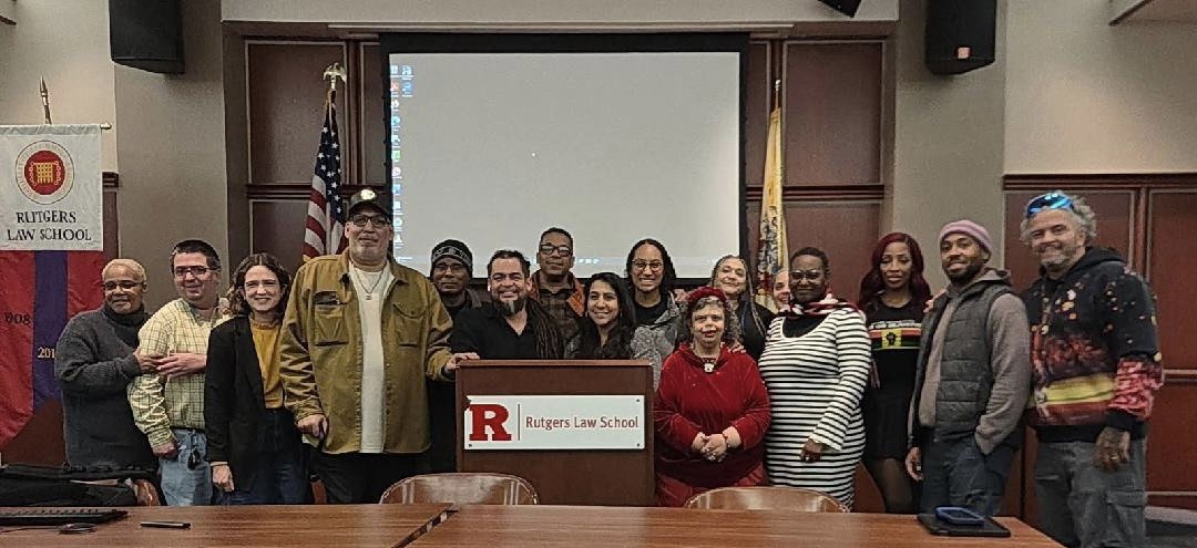 Network members and supporters standing together at a lectern at Rutgers Law School