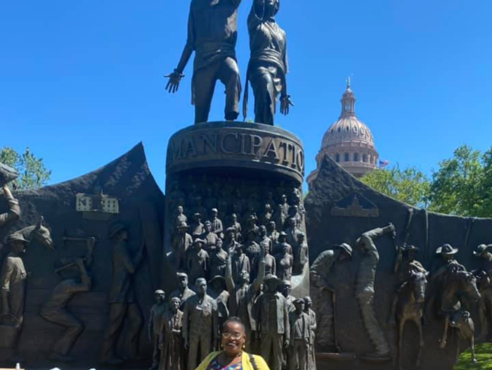 Savannah Eldrige in front of the Texas State Capitol and the New Texas African American Monument
